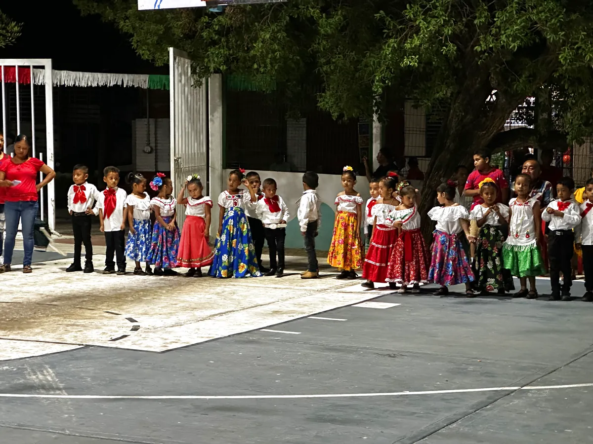 Niños de la escuela de Agua Zarca, vestidos con trajes regionales, formados y listos para salir a bailar.